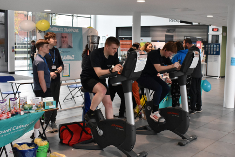 Public and Uniformed Services students using exercise bikes as part of their fundraising activities for Bowel Cancer UK.