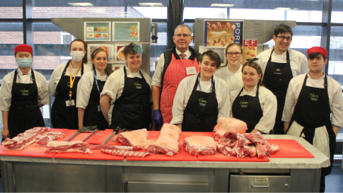 Students smile with Ian Shuker following their pork butchery masterclass.