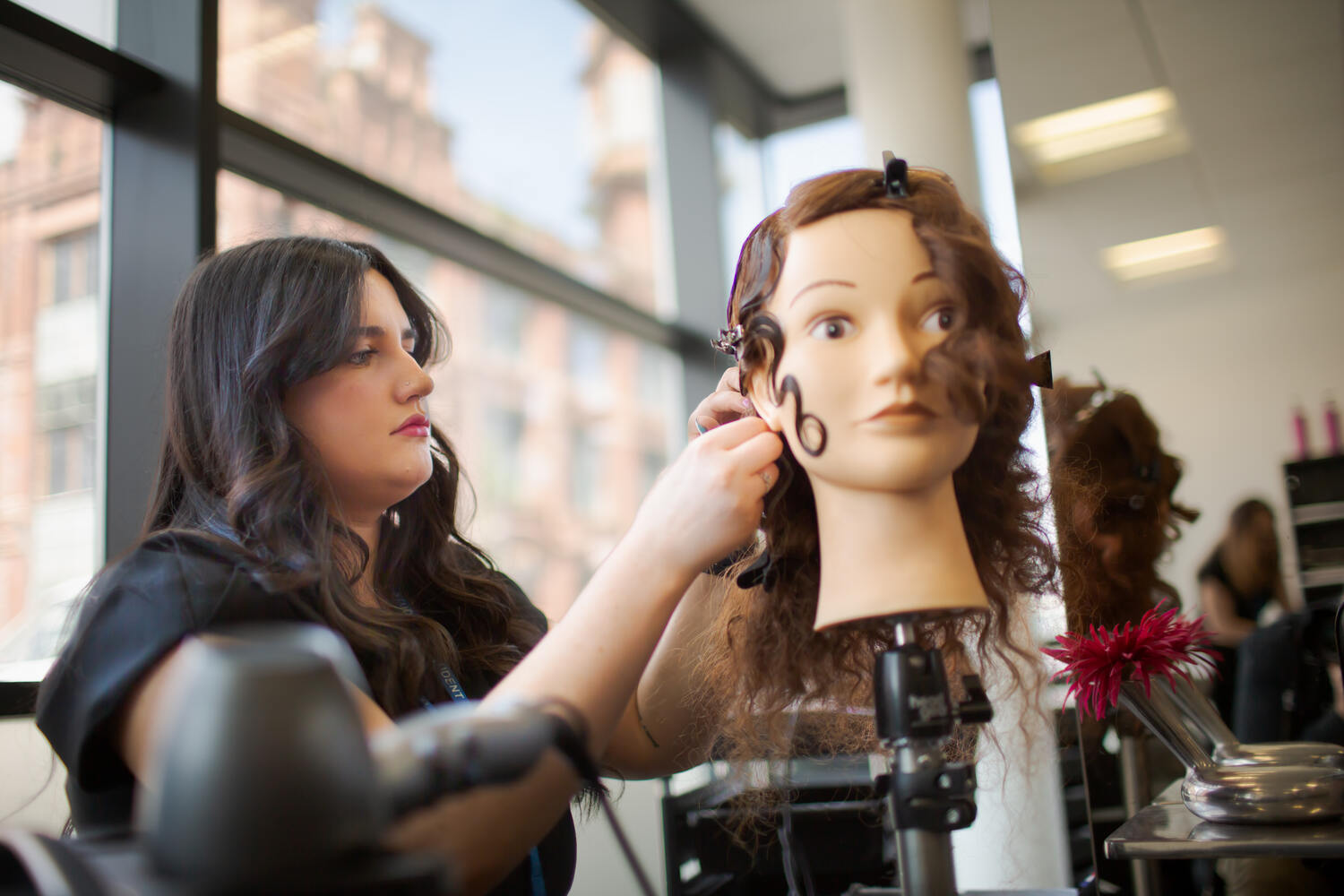 hairdressing student styling on a mannequin