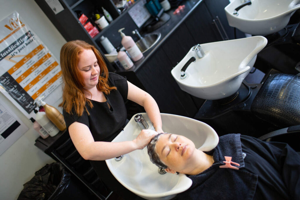 hairdressing student washing a clients hair