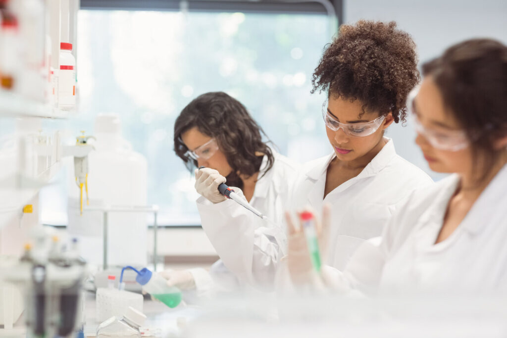 three female science students conducing an experiment