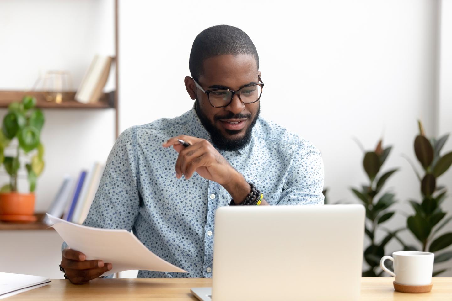 Male student sat at desk looking at their laptop