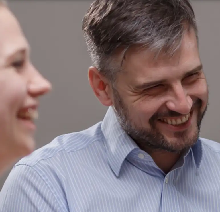 close up of a man in a blue shirt and women smiling