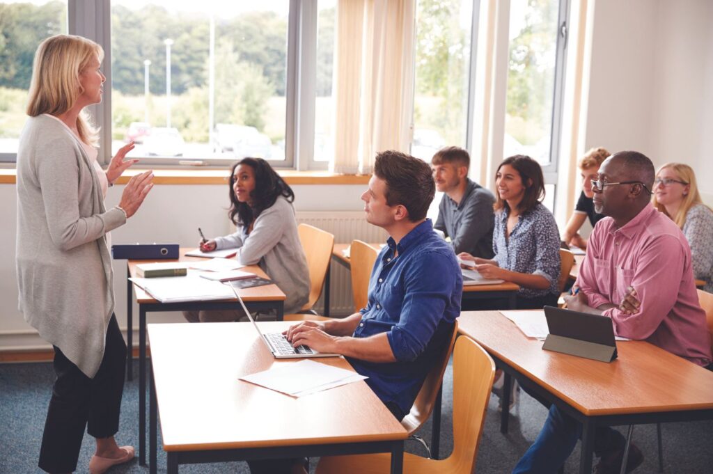 Students in a classroom listening to a tutor