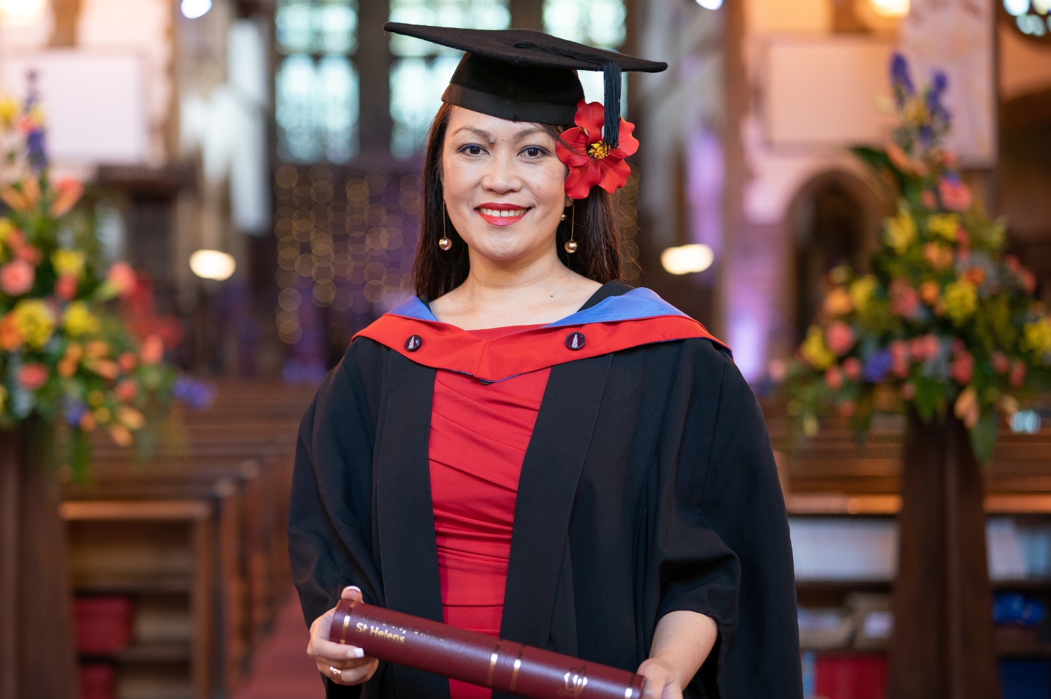 University Centre student in cap and gown holding a scroll