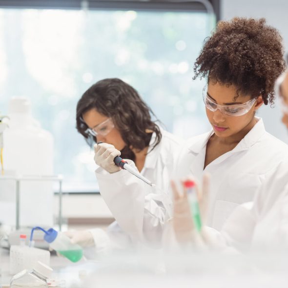 three female science students conducing an experiment