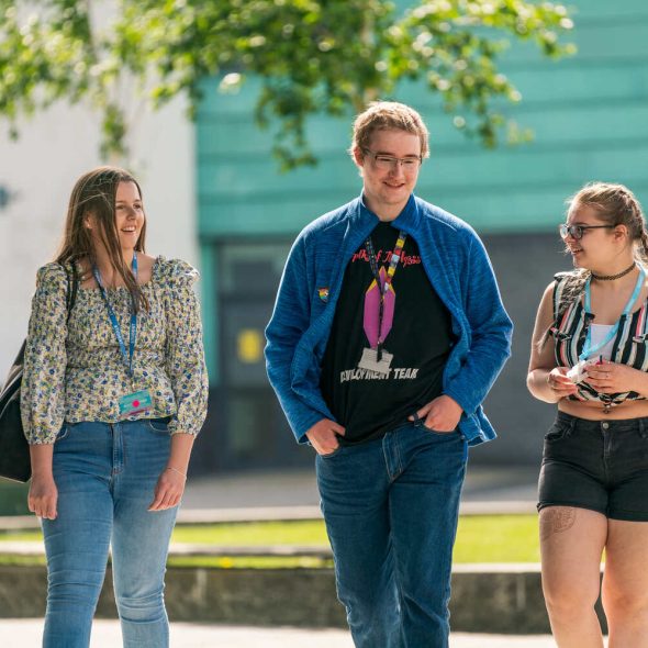 three students walking outside St Helens College