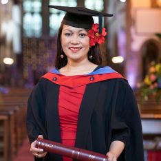 University Centre student in cap and gown holding a scroll